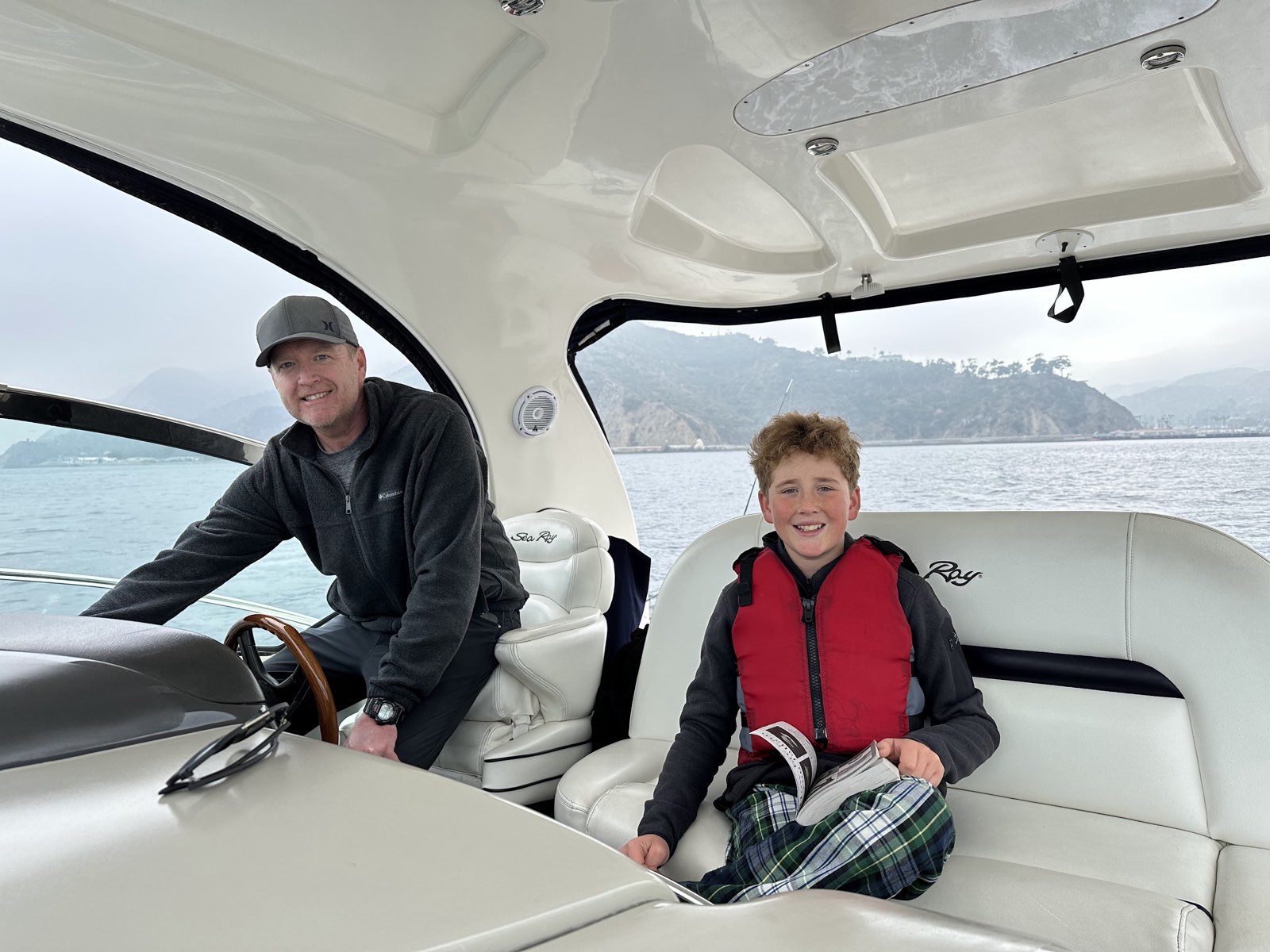 David with his son aboard on a clear Newport Beach day